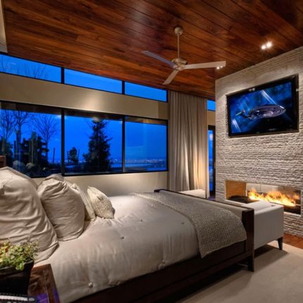 A bedroom with a fireplace and a flat screen tv.