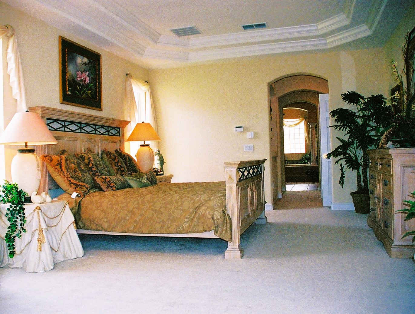 A bedroom with a bed, chair and lamp.