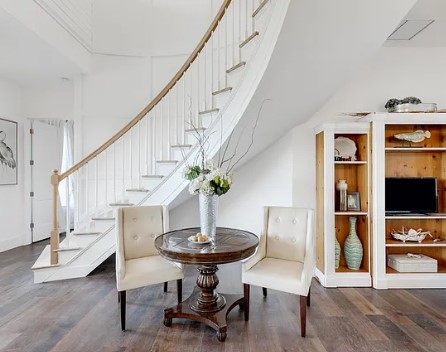 A table and chairs in front of the stairs.